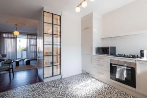 a kitchen with white cabinets and a living room at 201 Cascades l 2 Bed Boutique Aparthotel in Cape Town