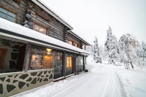 a log cabin with snow on the ground at Villa Naava Ruka in Kuusamo