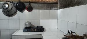 a kitchen with a stove and pots and pans at Noor Homestay Tetebatu in Tetebatu