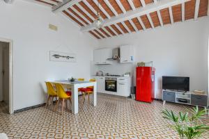 cocina con mesa, sillas y nevera roja en Casa Le 3 B con vista mare, en Portoferraio 13 fotos más