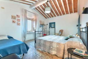 Un dormitorio con dos camas y una mesa y una ventana. en Casa Le 3 B con vista mare, en Portoferraio