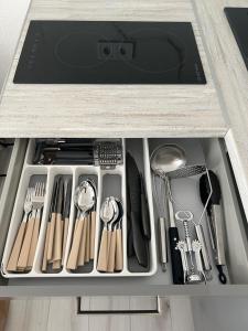 a drawer filled with cooking utensils in a cabinet at Luxusný Apartmán Váh in Hlohovec