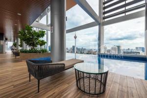 Cette chambre dispose d'une table en verre et offre une vue sur la ville. dans l'établissement THE COLONY INFINITUM Sweet Home SR, à Kuala Lumpur