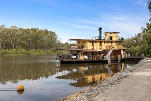 a house boat is docked on a river at TORRUMBARRY MOTEL in Torrumbarry