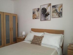 a bedroom with a bed with four pictures on the wall at Holiday Grivi in Enna