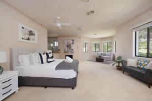 a bedroom with a large bed and a couch at The Valley Way Luxury Estate in Tuggerah +25 photos