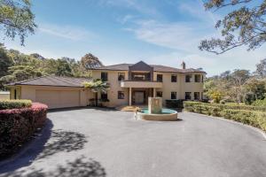 a house with a driveway and a garage at The Valley Way Luxury Estate in Tuggerah