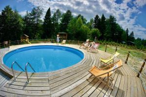 a group of people sitting around a swimming pool at Ośrodek Wypoczynkowy Mamczur Pizuny in Łukawica
