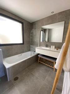 ソトグランデにあるBest seaview luxury duplex BlueSuite 4303の浴槽と洗面台のあるバスルーム