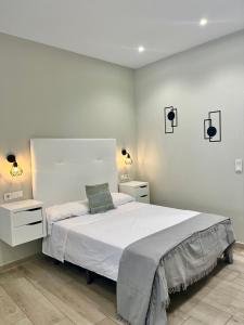 a bedroom with a white bed and two night stands at Califa SuitesGP in Córdoba