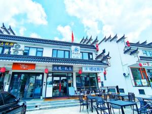 un edificio con tavoli e sedie di fronte di 九华山风景区随侣同行民宿 a Jiuhua