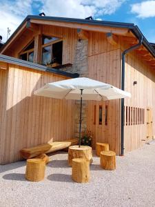 an umbrella and benches in front of a building at Chalet Matilde in Padola