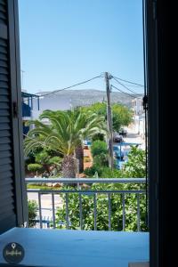a view of a palm tree from a window at Seaside Apartments in Emporeios