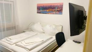 a room with a bed with a tv and a chair at Tolle FeWo direkt am Campus 24-7 Checkin in Germersheim