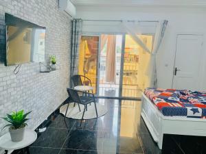 a bedroom with a bed and a chair and a window at Studio Le Parisien in Pointe-Noire