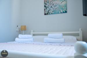 a white bed with towels on top of it at Seaside Apartments in Emporeios