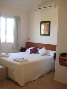 Un pat sau paturi într-o cameră la Hotel Queguay