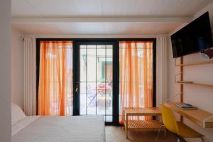 a bedroom with a bed and a desk and a balcony at Aurora in Rome