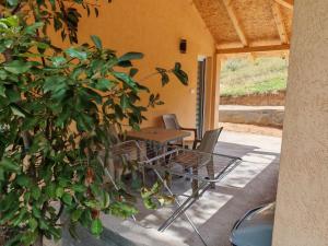 a patio with a table and chairs next to a tree at Porta Simića in Ribarska Banja