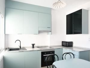 フェロルにあるApartamento Porta Novaのシンクとコンロのある白いキッチン