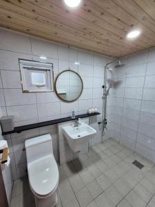 a bathroom with a toilet and a sink and a mirror at Yeonyijae hanok stay in Gyeongju +28 photos