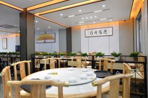una sala da pranzo con tavoli e sedie in un ristorante di 九华山风景区随侣同行民宿 a Jiuhua