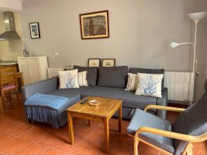 Una sala de estar con un sofá azul y una mesa. en Casa con 2 apartamentos y garaje A 20 min de Sierra Nevada, en Güéjar-Sierra