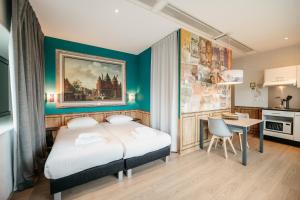 a bedroom with a bed and a table and a kitchen at Amsterdam ID Aparthotel in Amsterdam