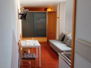 a small living room with a table and a couch at Apartamentos Las Tuyas 3000 in Sierra Nevada