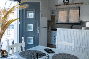 a kitchen with a table and a blue door at Seaside Apartments in Emporeios