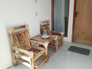 a table and chairs sitting next to a door at Ilham Homestay in Kuta Lombok