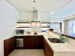 eine Küche mit Spüle und Mikrowelle in der Unterkunft COZY Studio in A La Carte Da Nang in Đà Nẵng