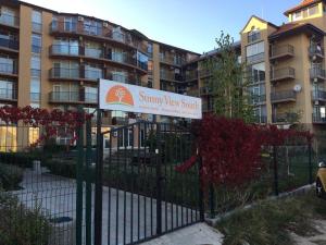 a sign on a fence in front of a building at Sunny view South studio Мир Авангарда in Sunny Beach