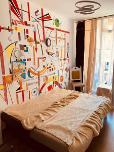 a bedroom with a wall covered in colorful art at Sunny view South studio Мир Авангарда in Sunny Beach