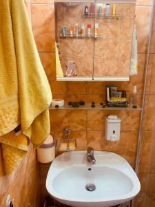 a bathroom with a sink and a yellow towel at Sunny view South studio Мир Авангарда in Sunny Beach