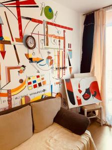 a living room with a couch and a wall covered in art at Студия Мир Авангарда in Sunny Beach +24 photos