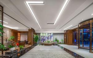 a lobby of a hotel with plants on the ceilings at Metropolo Hotel Xuzhou High-speed Railway Station Jinlonghu in Xuzhou