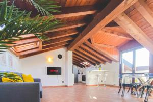 a living room with wooden ceilings and a table and chairs at Castelletto - Armonia rustica e moderna in Bressana Bottarone +32 photos