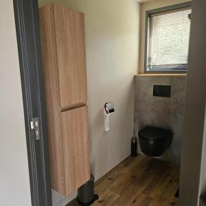 a bathroom with a black toilet and a window at MOI -Magnifiek Overnachten In- Meppen in Meppen +24 photos