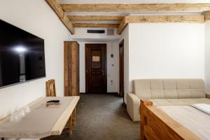 a living room with a bed and a table at Păstrăvăria Alex in Mara