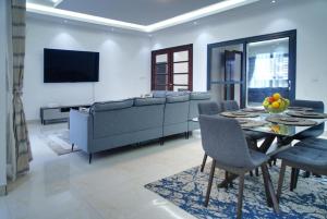 a living room with a couch and a table and chairs at Mandela Suite, Ngor Almadies, Dakar, Senegal Appart 2 chambres, 2 salles de bain in Dakar
