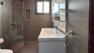 a bathroom with a sink and a shower at Mandela Suite, Ngor Almadies, Dakar, Senegal Appart 2 chambres, 2 salles de bain in Dakar