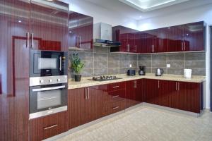 a kitchen with wooden cabinets and a stove and microwave at Mandela Suite, Ngor Almadies, Dakar, Senegal Appart 3 chambres, 3 salles de bain in Dakar