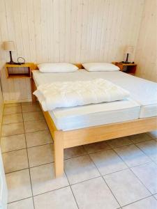 a bed in a room with two pillows on it at Ferienhaus Bungalow Schloß Dankern für 6 Personen in Haren