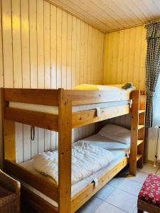 two bunk beds in a room with wooden walls at Ferienhaus Bungalow Schloß Dankern für 6 Personen in Haren +5 photos