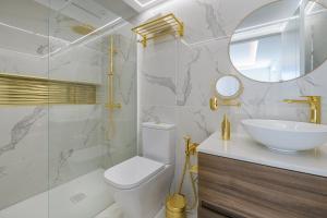 a bathroom with a sink and a toilet and a mirror at Grand Horizon Luxury Boutique Apartments in Puerto Rico de Gran Canaria