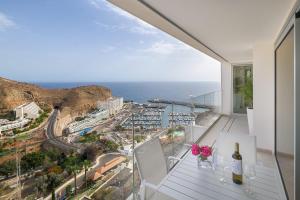 a balcony with a bottle of wine and flowers on it at Grand Horizon Luxury Boutique Apartments in Puerto Rico de Gran Canaria