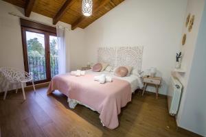 a bedroom with a bed with pink sheets and a window at Casa Rural: La Tarara in Galinduste +62 photos