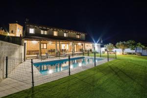 a house with a swimming pool at night at Casa Rural: La Tarara in Galinduste