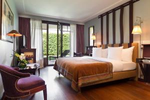 una camera d'albergo con letto e sedia di La Réserve Genève Hotel & Spa a Ginevra Altre 29 foto
